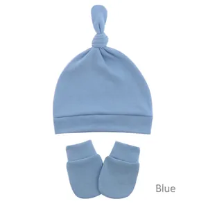 Detailed view of blue knitted cotton newborn knotted hat and anti-scratch mittens set
