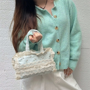 Détail du sac cabas en toile fleurie avec bordure en dentelle blanche et motif menthe