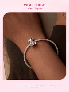 Pulsera de plata S925 con dije de oso y corazón rosa mostrada en el brazo de una modelo