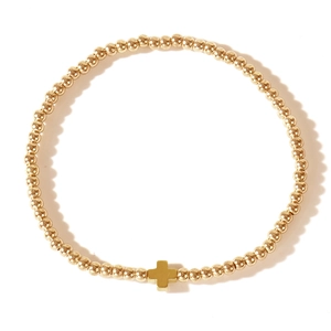 Minimalist gold beaded bracelet with a cross pendant on a clean white background