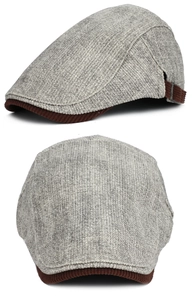 Detail of tweed flat cap featuring corduroy brim and adjustable side strap