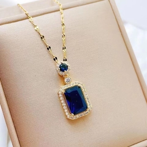 Close-up of golden necklace with rectangular blue gemstone pendant on a jewelry box