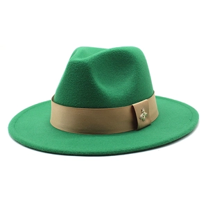 Detail of wide brim green wool fedora hat with brown ribbon and small metal bee accessory