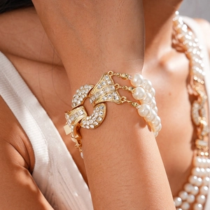 Close-up of luxury multi-layer bracelet with gold metal, crystals and imitation pearls