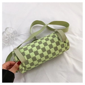 Detailed macro of green checkered cylinder bag with pleated texture and wide strap