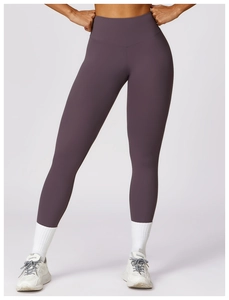 Detail of high-waisted seamless purple yoga leggings with sculpting fit on fitness model