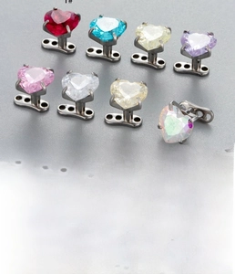 Detail view of heart-shaped zircon dermal anchors in various colors for body piercing