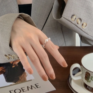 Detailed view of a 925 sterling silver ring with a pearl worn by a model in a cozy scene