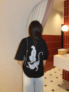 Relaxed fit black T-shirt featuring a white twin leopard print on the back for women