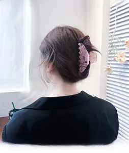 Detail of large acetate hair claw clip with pink marble texture on a woman's hair