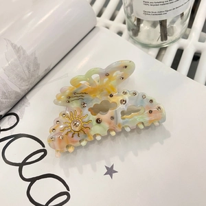 Pince à cheveux féerique en acétate avec soleil, lune dorés et strass étincelants
