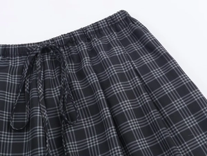 Detail of black and grey plaid shorts featuring an elastic waistband with adjustable drawstrings
