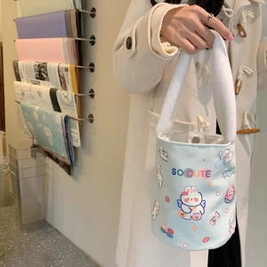 Secchiello in tela azzurra con stampa a coniglietto e manici in peluche su un cappotto