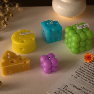 Artistic bubble cube and cheese candles with decorative tags in a cozy home setting