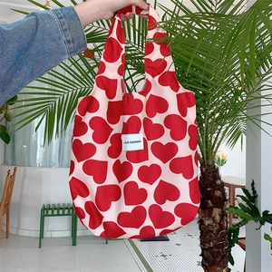 Close-up of pink corduroy tote bag with red heart pattern and LOVE SOZAKKA label