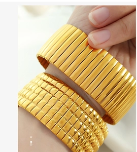 Makrodetail eines vergoldeten Edelstahlarmbands mit quadratischem Gitter und Gliederketten