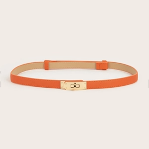 Detail of orange Saffiano leather skinny belt with elegant golden metal turn-lock buckle