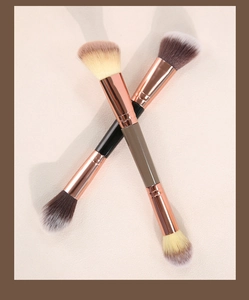 Dual-ended contour brush with rose gold ferrule and soft fluffy bristles on beige surface