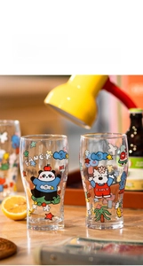 Detail view of transparent glass cups with cute cartoon panda and dog prints