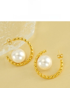 Macro detail of 18K gold plated C-shaped pearl earring with textured bead pattern