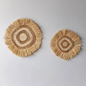 Detailed macro view of bohemian round straw wall decor featuring natural raffia texture