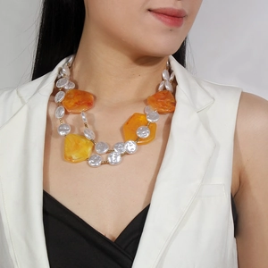 Detail of amber resin blocks and white pearl beads on a double-layer necklace set