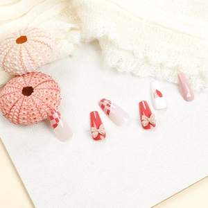 Grapefruit red checkerboard press-on nails with 3D bows and heart patterns on long coffin tips