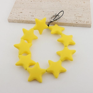 Detailed close-up of yellow star-shaped beads on a phone strap with a metal ring