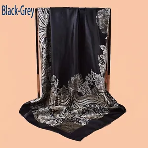 Macro detail of black and grey paisley floral silk scarf draped on a chair