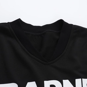Detail of black V-neck jersey sweatshirt showing ribbed knit texture and white lettering