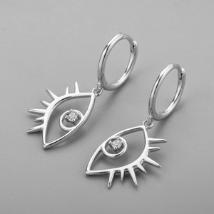 Macro detail of silver evil eye earrings with white zircon stones and metal texture