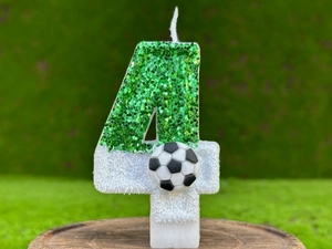 Gros plan d'une bougie d'anniversaire foot numéro 4 avec paillettes vertes et ballon