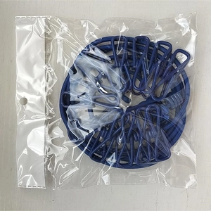 Close-up of a blue retractable elastic clothesline with 12 clips in clear plastic packaging