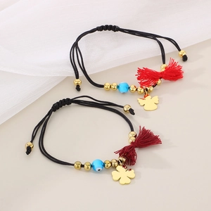 Detail of handmade woven bracelets featuring evil eye and four-leaf clover charms