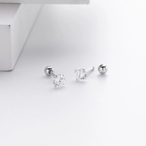 Detail of silver S925 screw-back stud earrings featuring four-prong set round cubic zirconia