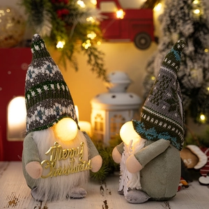 Nahaufnahme von Weihnachtswichteln mit Leuchtnase, Merry Christmas Schild und Schneeflocke