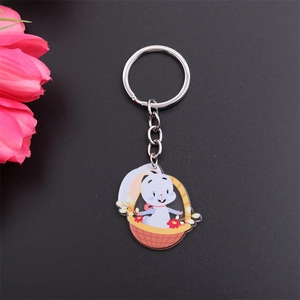 Detail view of a cute white rabbit in a basket keychain with a sleek black background