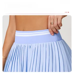 Detail of light blue pleated tennis skirt featuring a wide contrast striped waistband