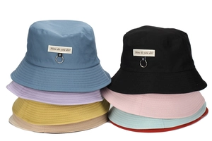 Detail of cotton sun hats showing various colors with metal ring and text label