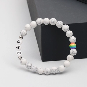 Detail view of the Father's Day bracelet with white marble beads and DAD letter charms