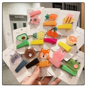 Handheld display of colorful children's hair clips featuring cute fruit and animal shapes