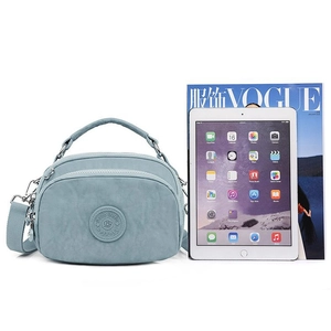 Light blue nylon crossbody bag with multi-zipper layers and adjustable fabric strap