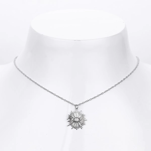 Macro detail of silver S925 Evil Eye necklace with sunburst pendant on a model neck