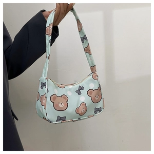 Close-up of a blue shoulder bag featuring cute brown bear prints and a zipper closure