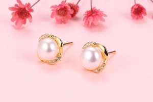 Macro shot of S925 silver crown pearl stud earrings with zircon inlay on pink background