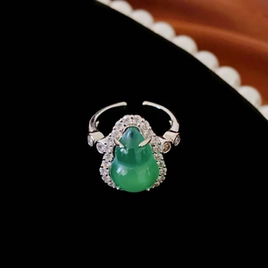 Detailed macro of a green resin gourd ring with cubic zirconia on a silver-tone band