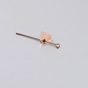 Macro shot of rose gold triangle charm bead and metal bar for DIY jewelry making