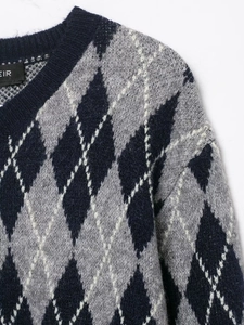 Close-up of argyle pattern knit fabric with soft texture and ribbed V-neckline detail