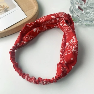 Close-up of red paisley pattern headband with twisted knot design and elastic band