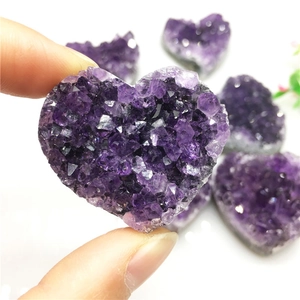 Natural heart-shaped amethyst cluster crystal specimen held by hand in macro view